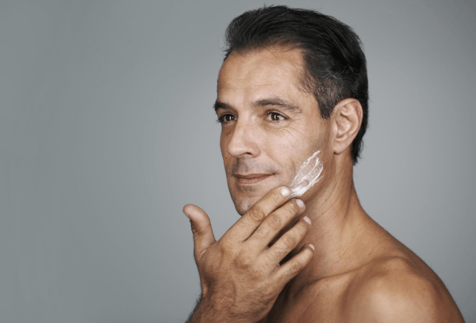 Image of a mature male applying anti-ageing cream to his face.