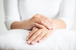 An image of a woman's hands over a white towel