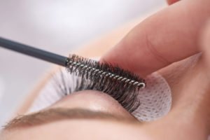 Image of a beautician brushing a woman's eyelash