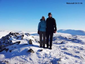 An image of walkers at the snowy summit of bakesall.