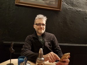 An image of Martin Leslie on his phone in a cafe.