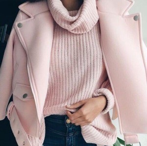 A close up image of a stylish woman sporting a pink coat and pink sweater