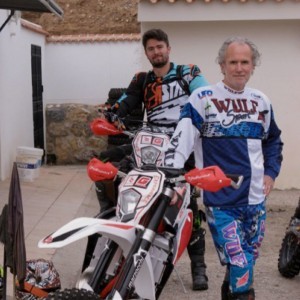 An image of Phil Hollingdale in his motorcross gear next to his motorbike.