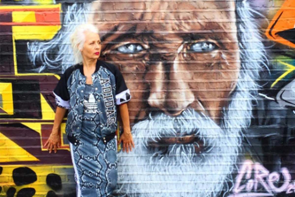 An image of Sarah Jane Adams posing in Adidas in front of graffiti art.