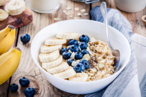 An image of a healthy breakfast consisting of oats topped with banana and blueberries.