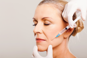 An image of a senior woman getting botox treatment to reduce wrinkles and fine lines.