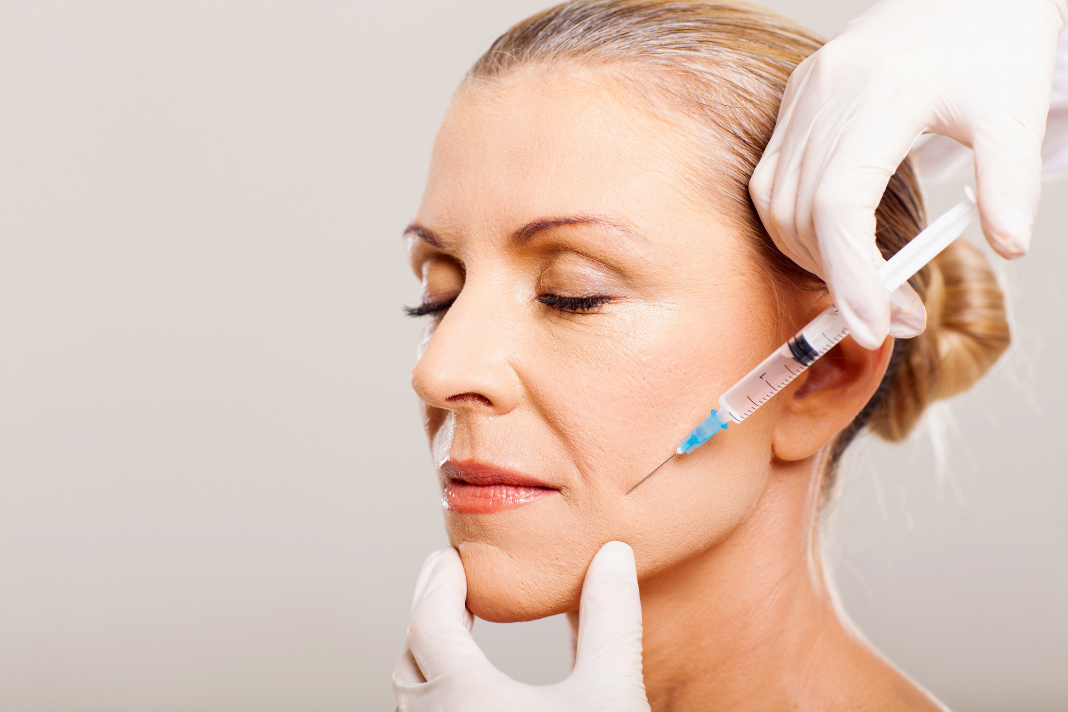 An image of a senior woman getting botox treatment to reduce wrinkles and fine lines.