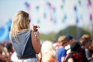 An image of a midster on her phone at the Glastonbury festival