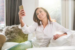 An image of a middle aged woman taking a selfie with her phone.