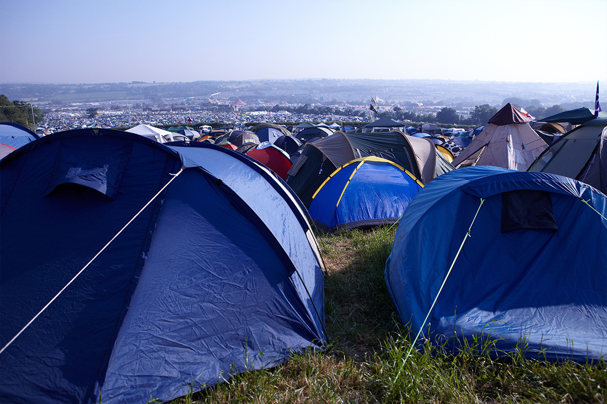 An image of rows upon rows of tents in the fields of Glastonbury festival.