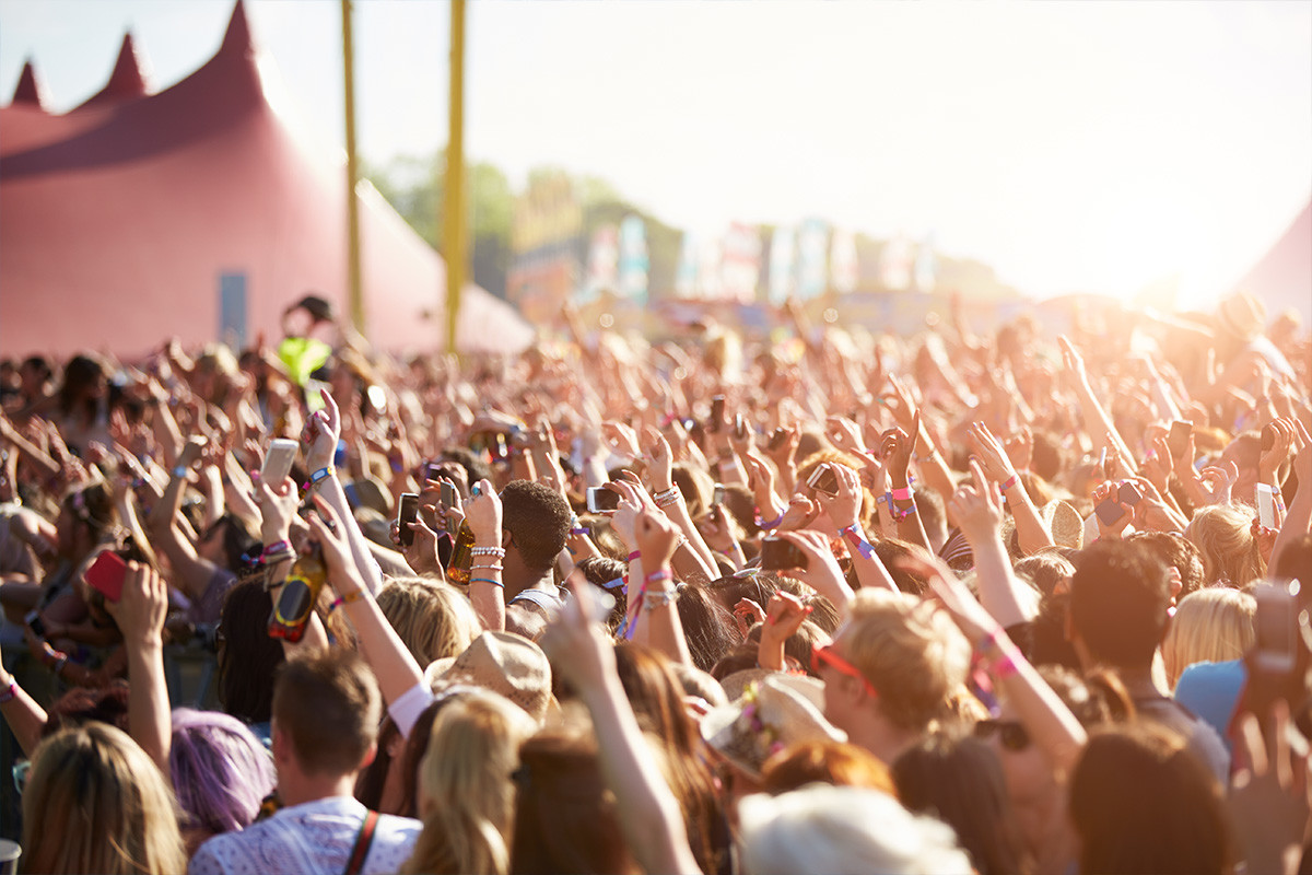 An image of an excited crowd dancing at a festival.