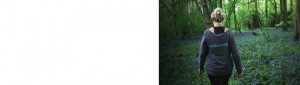 An image of middle aged Tracy walking in the bluebell woods in a rejuvage midster vest with a darker tint,