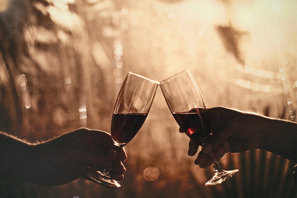 An image of two over 40s clinking wine glasses.