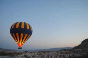 An image of a hot air balloon looking over beautiful valleys.
