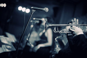 A black and white image of trumpet player performing in a jazz band.
