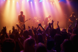 An image of a crowd cheering a bland playing at a live music gig.