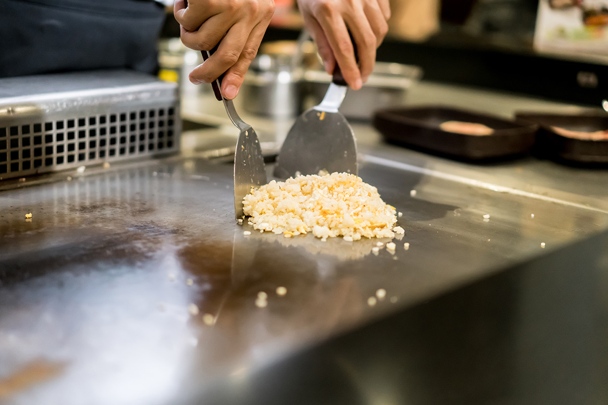 An image of a chef cooking at a a teppanyaki restaurant 