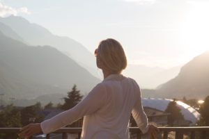 An image of a middle aged woman looking at a beautiful view.