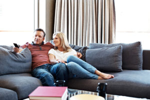 An image of a relaxed couple on a sofa watching netflix.