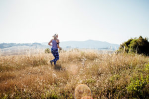 An image of a mature woman running through a field.