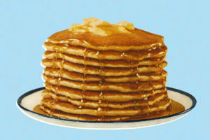 An image of pancakes drizzled in maple syrup topped with butter on a blue background.