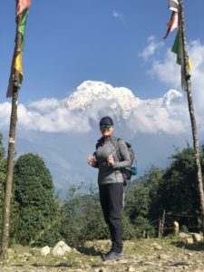 louise in nepal carrying a backpack with mountains in the background