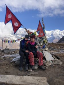 picture of louise and her daughter in Nepal with mountains in the background and flags