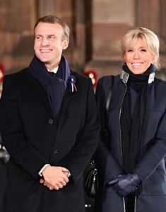 couple formally dressed wearing a coat and scarf smiling at the camera