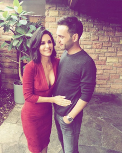 celebrity couple Courtney cox in red dress hugging partner