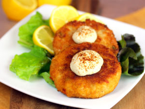 golden crab cakes with a side salad and two dollops of dijon mustard
