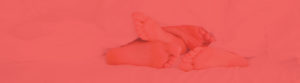 two peoples feet stick out of the bed sheets at the bottom of the bed with red wash filter over the top
