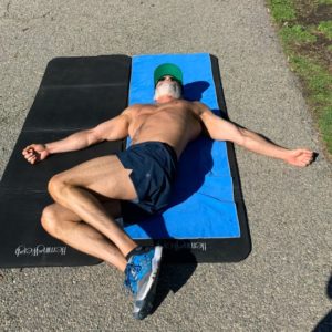strong mature man lay on a yoga mat stretching his back