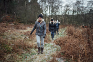 Four women are enjoying a walk through the woodland together in winter.