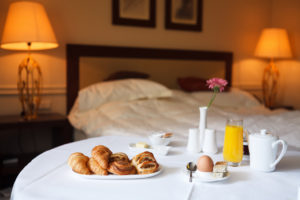 breakfast in bed. Room service in a hotel with pastries, an egg and orange juice