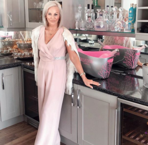 mature woman in blush coloured jumpsuit in a modern kitchen