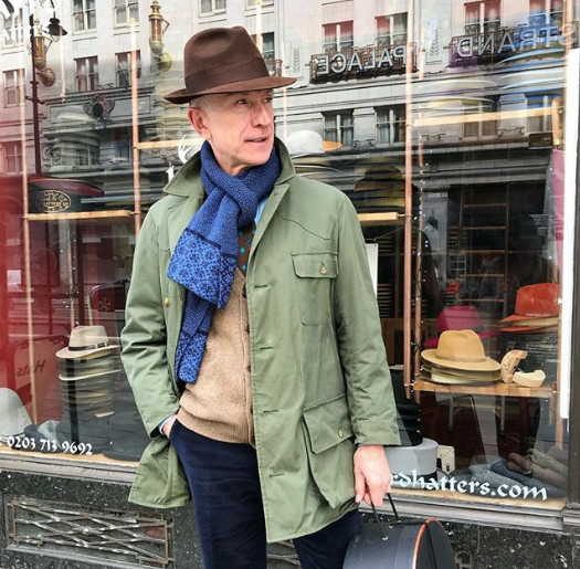 stylish mature man outside hat shop after purchasing a new hat