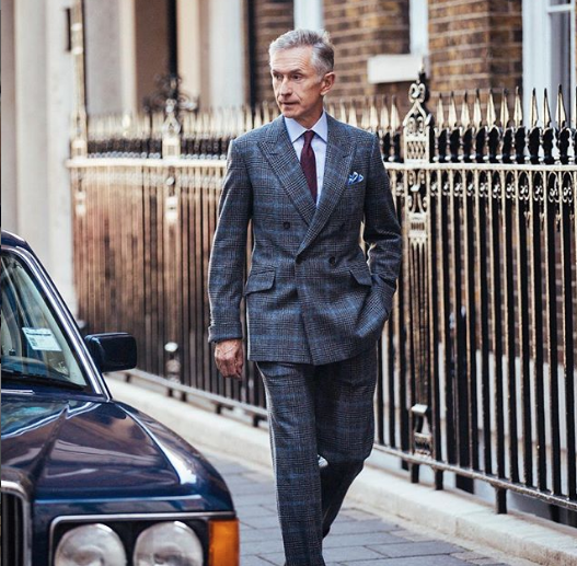 mature man in stylish grey suit walking don the street