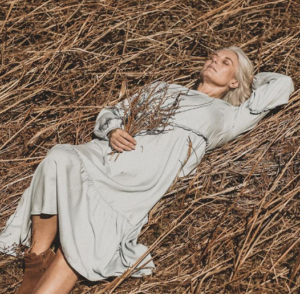 stylish spring fashion - middle aged woman lay in field relaxed