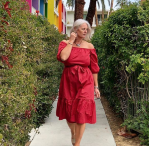 fashion forward middle aged woman walking outdoors in red dress