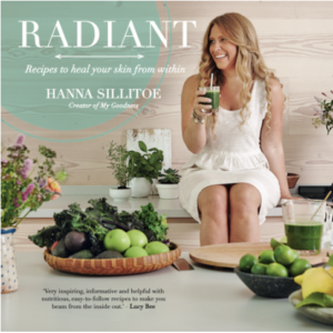 image of a woman sitting on the table top of a modern kitchen drinking a health drink