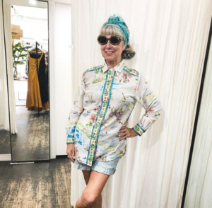 middle aged woman wearing fun sunglasses and bold top having fun with fashion