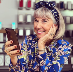 middle aged woman looking stylish in bold colours and patterns looking at her phone