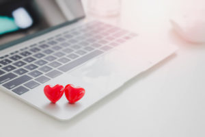 close up photo of a laptop with two red love hearts on it