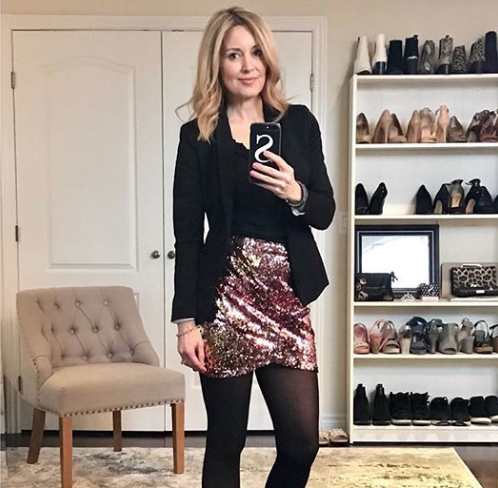 middle aged woman looking stylish in black blazer and sparkly skirt