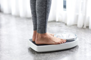 woman's feet on scales as she weighs herself