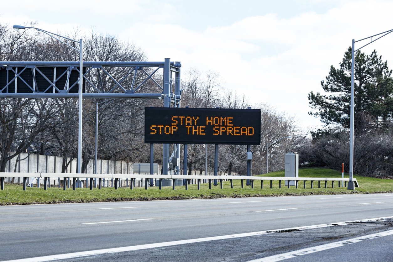road sign saying "stay home stop the spread"