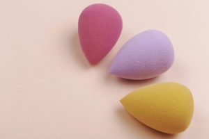 colourful beauty blenders on a pink background