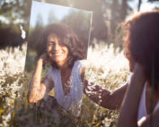 woman looking at herself in a mirror in the outdoors